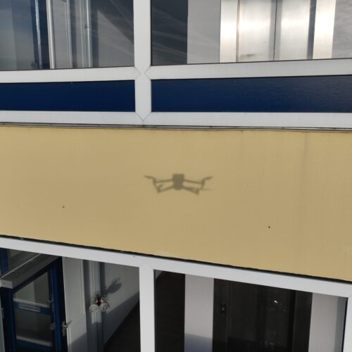 Schaduw van de inspectiedrone op de gevelbeplating