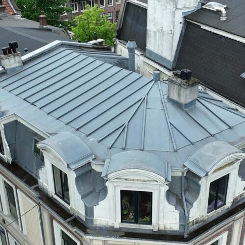 Drone-inspectie hoekpand Amsterdam: loden mansardedak met dakkapellen